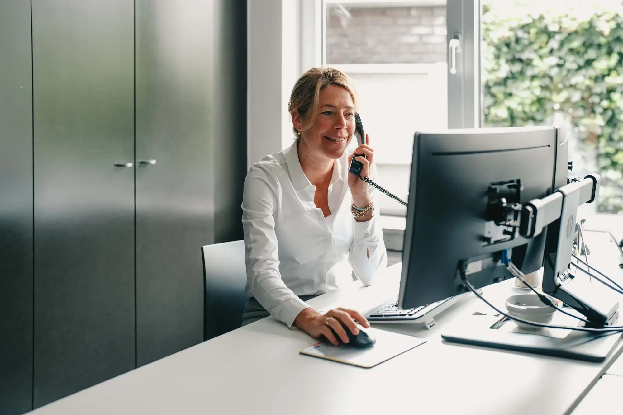 Een medewerker van Creafig aan het werk op kantoor, aan de telefoon