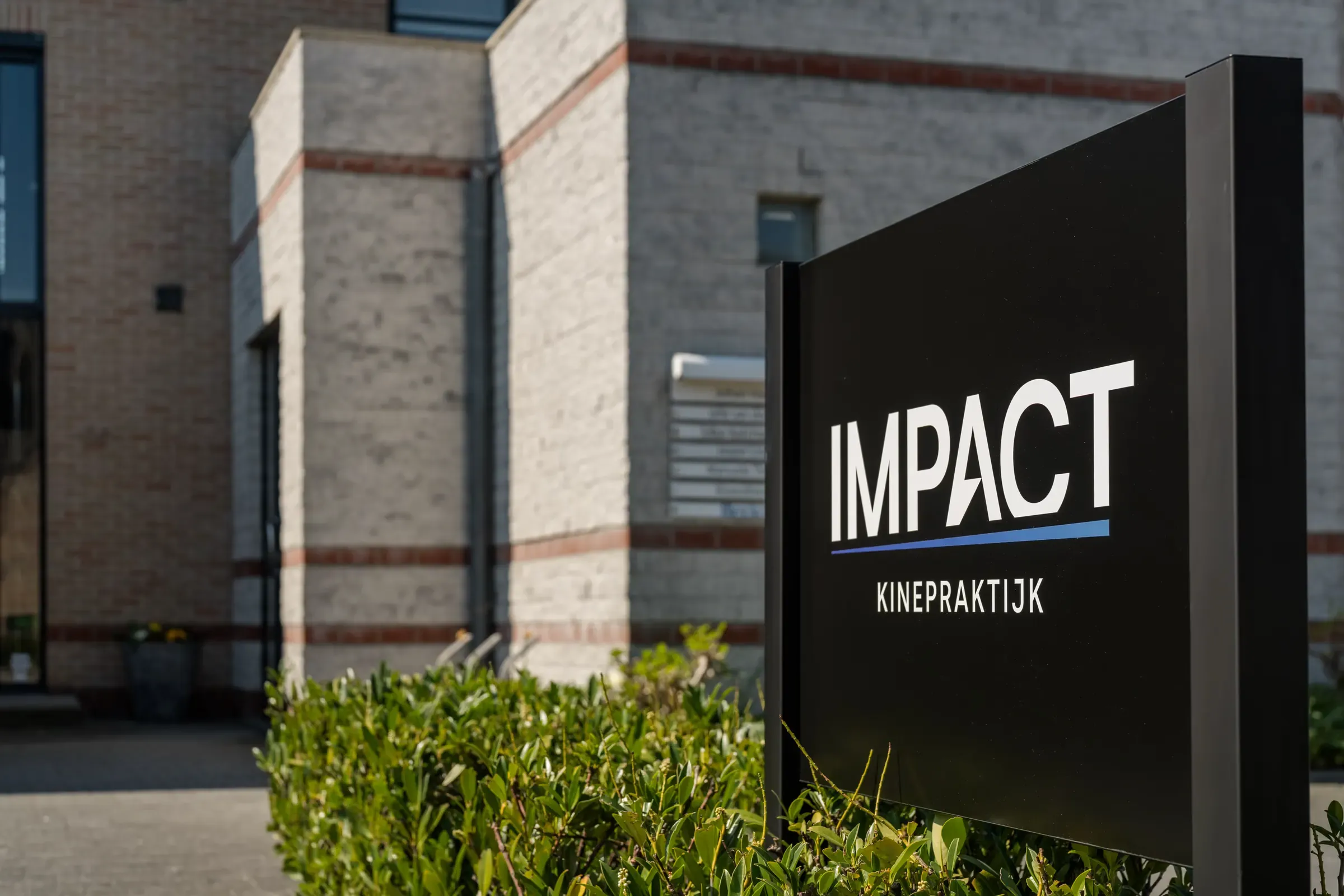 Het bord van Impact Kinepraktijk voor de praktijk in Pelt
