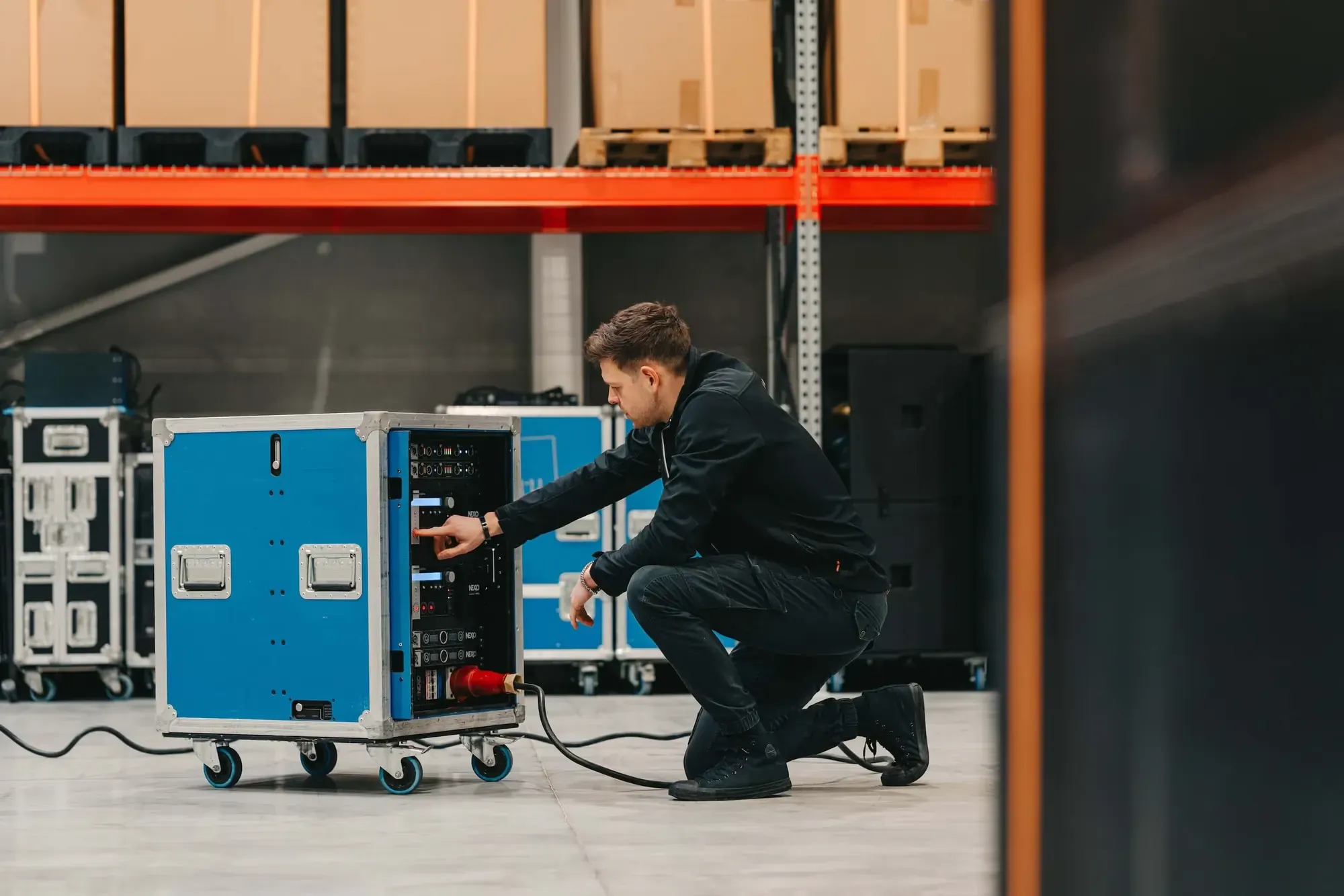 Jasper Coninx test een rack met versterkers in het magazijn