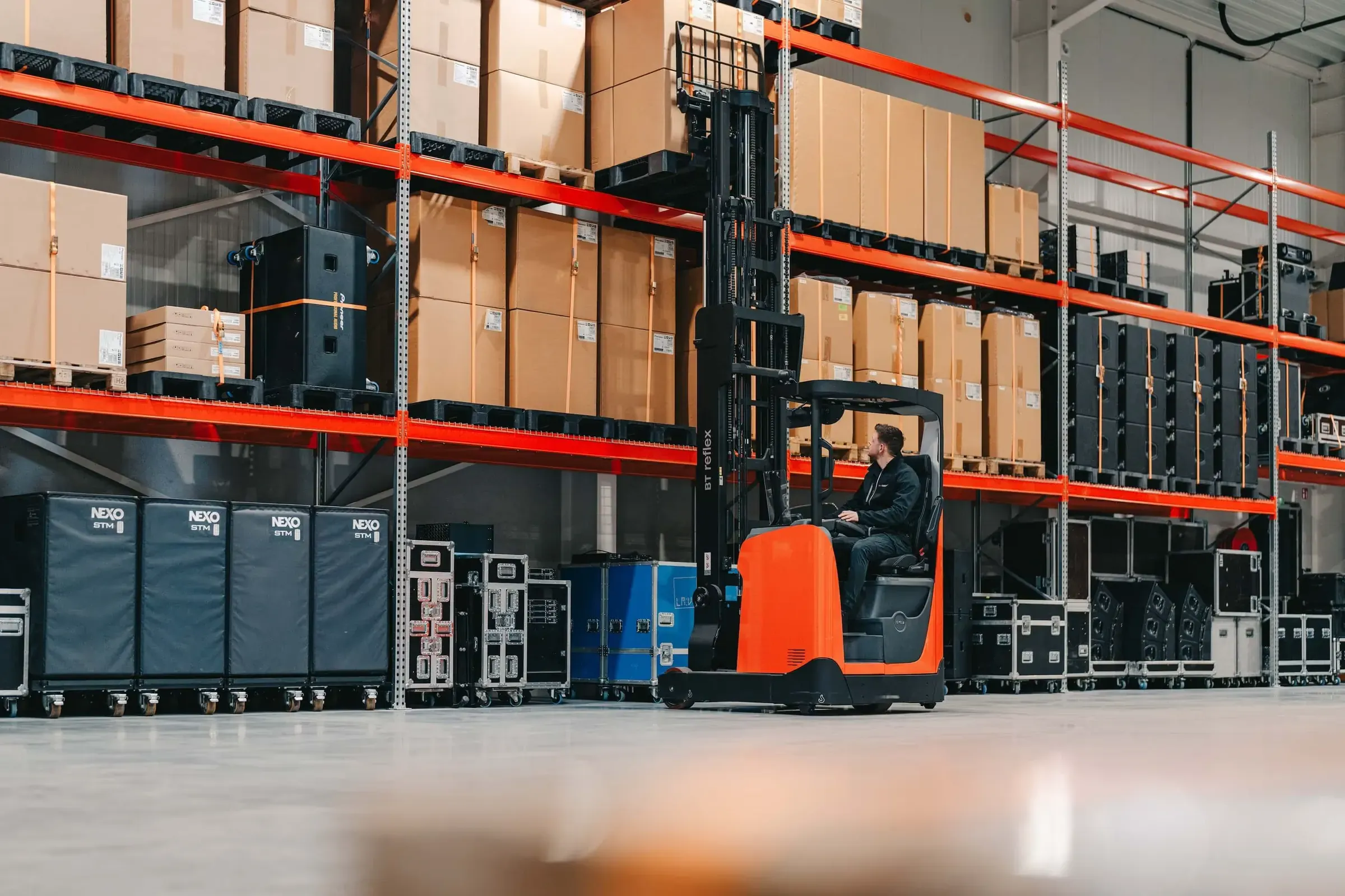 Jasper Coninx op de heftruck in het magazijn van Kinxsound in Pelt